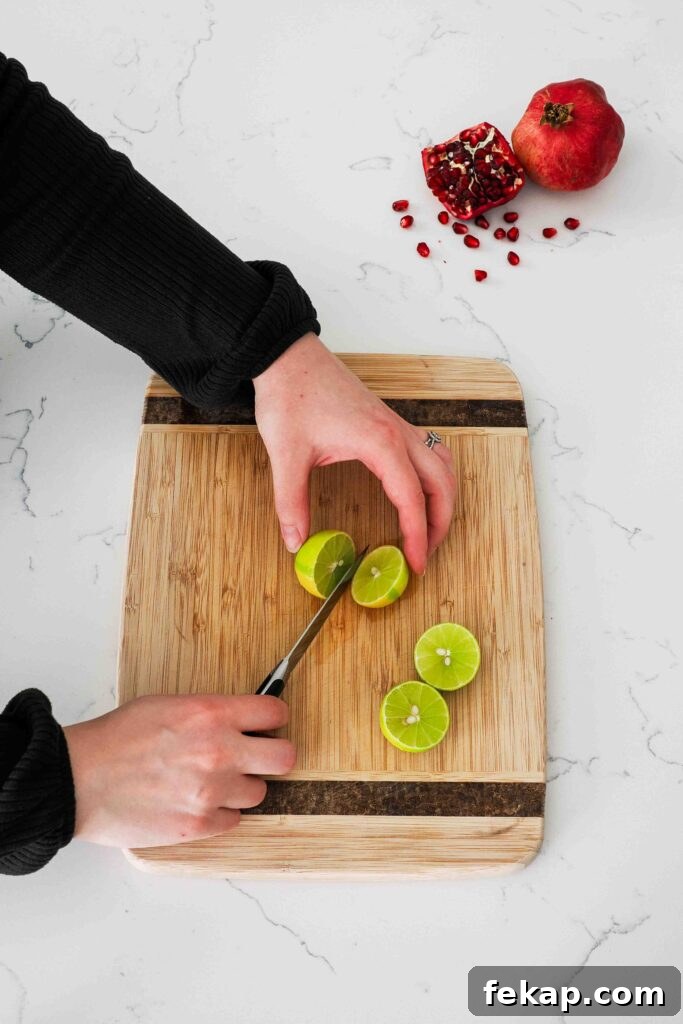 Homemade Pomegranate Sorbet Recipe 4 Small limes are cut in half on a cutting board.