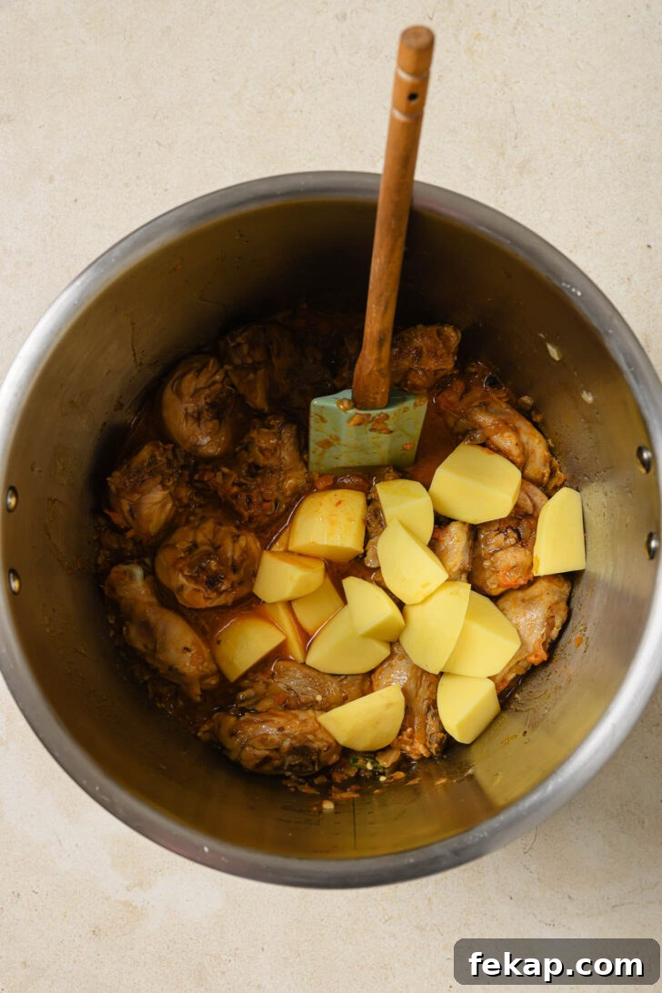 Potatoes added to Instant Pot with sautéed chicken to make Chicken Curry.