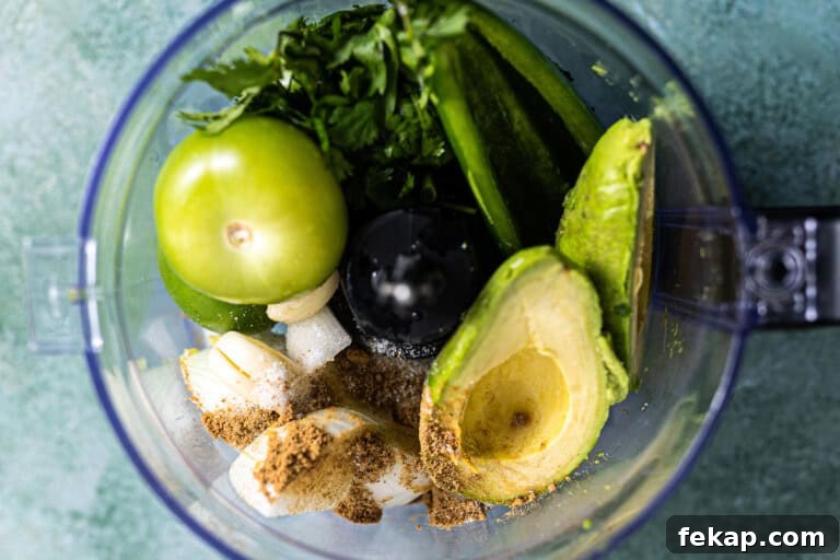 Ingredients needed for avocado salsa in a food processor.