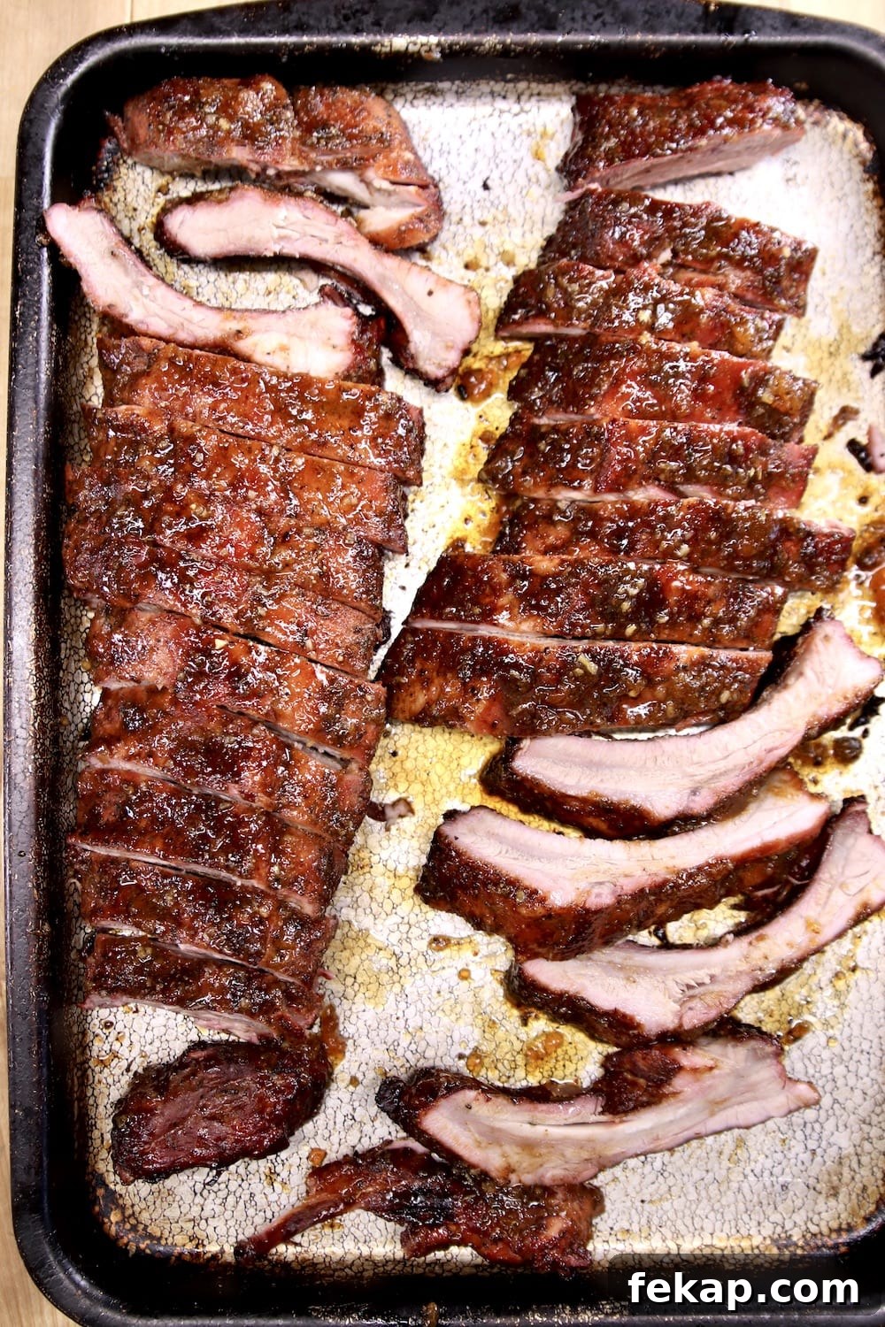 Apricot BBQ Ribs 2 racks baby back ribs with apricot bbq sauce, sliced on a sheet pan