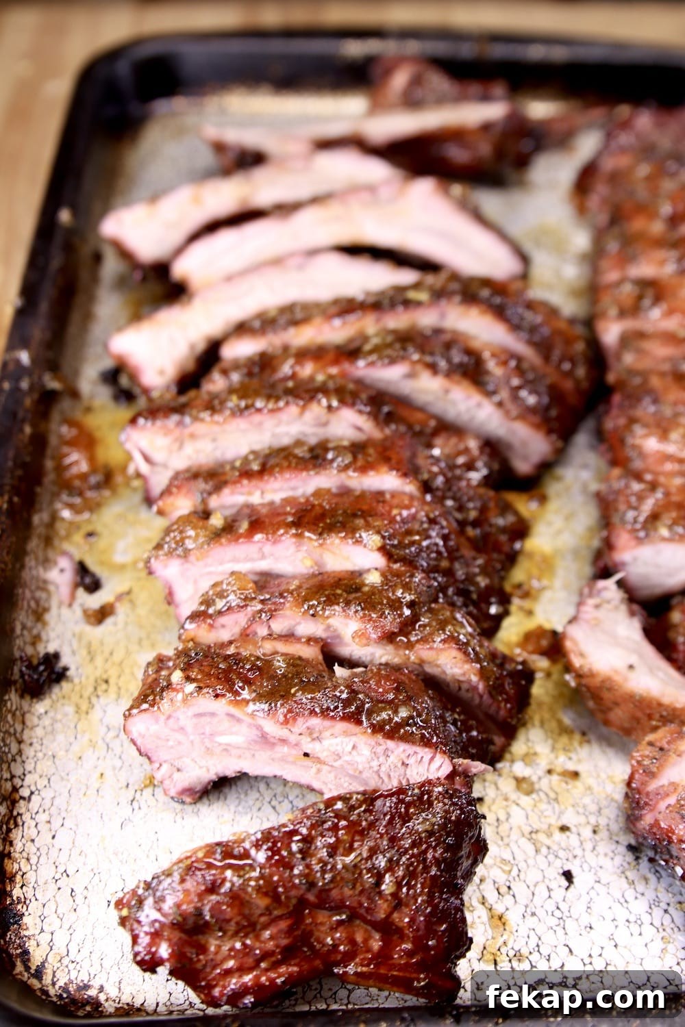 Sliced baby back ribs with apricot BBQ sauce sliced baby back ribs on a sheet pan