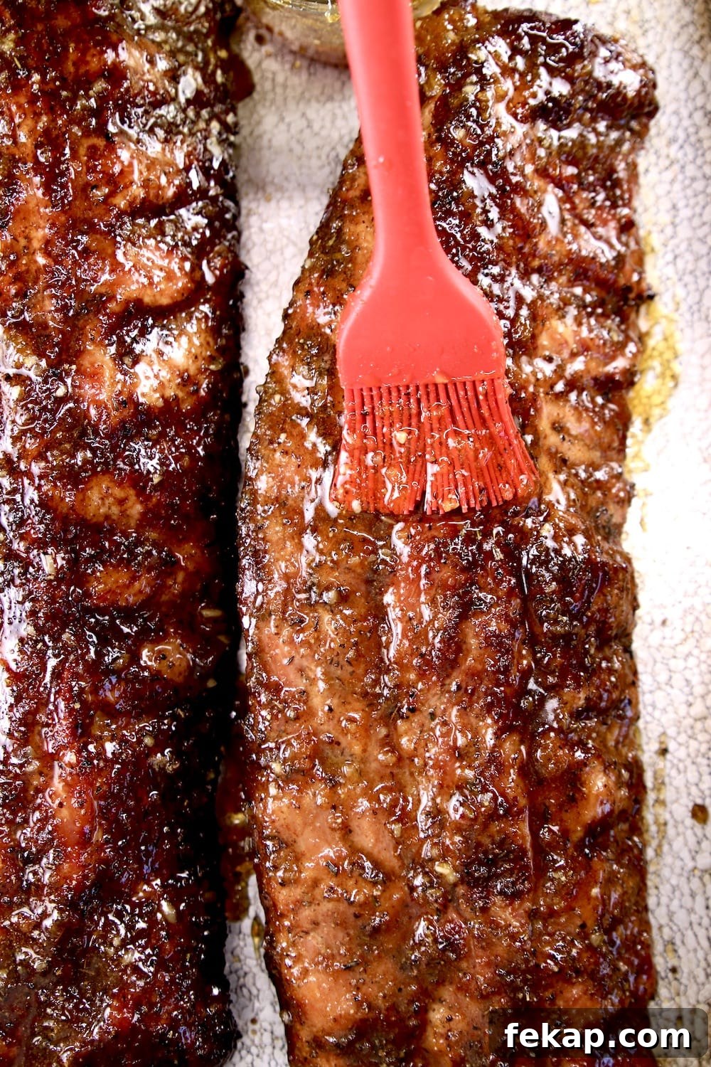 Brushing apricot BBQ sauce on ribs brushing bbq sauce onto smoked rack of ribs
