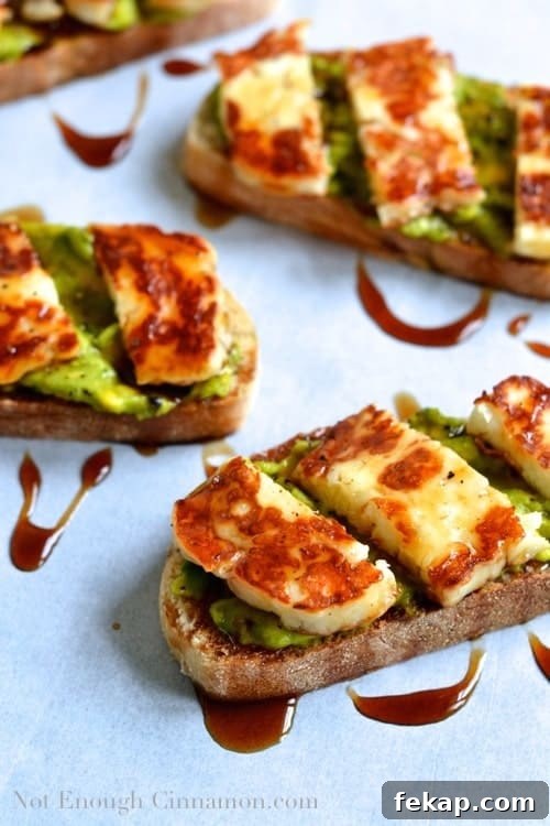Tartine topped with Grilled Halloumi and mashed Avocado and drizzled with Pomegranate Molasses - arranged on parchment paper