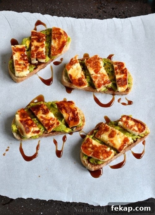 Overhead shot of Tartine topped with Grilled Halloumi and mashed Avocado and drizzled with Pomegranate Molasses - arranged on parchment paper