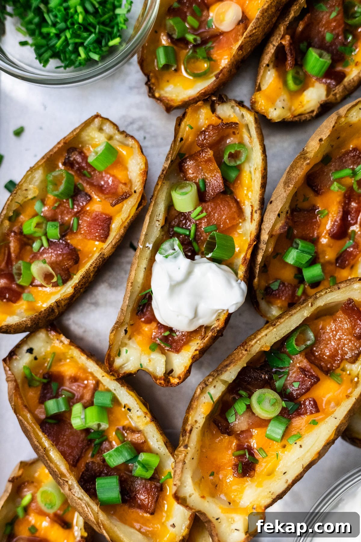 Crispy Potato Skins with Cheddar, Bacon and Green Onions 2 A top down view of loaded potato skins on a baking sheet