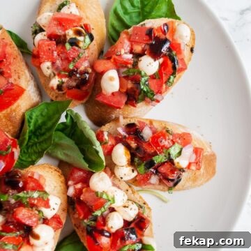 Crispy Potato Skins with Cheddar, Bacon and Green Onions 11 A top down view of a plate of bruschetta with mozzarella garnished with fresh basil leaves.