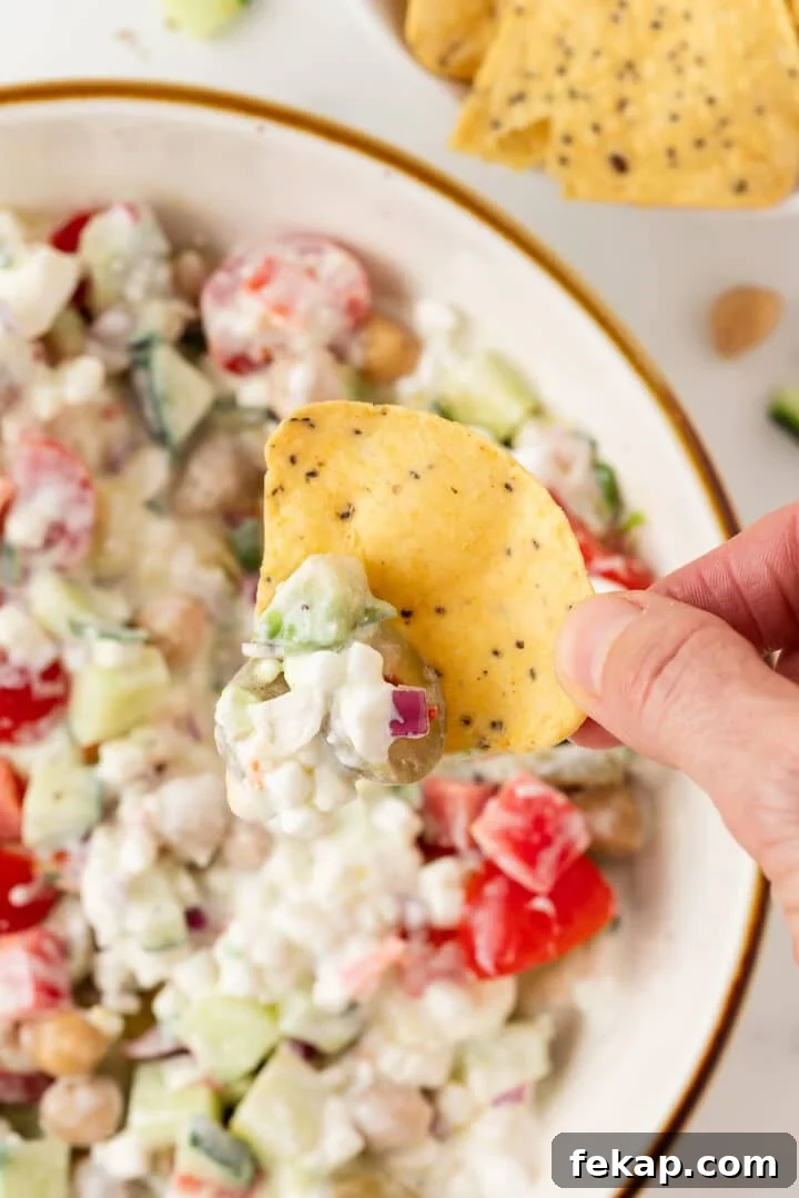 Cottage cheese greek salad scooped onto a tortilla chip.