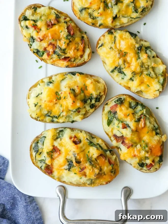 closeup of spinach and cheddar twice-baked potatoes on a white platter