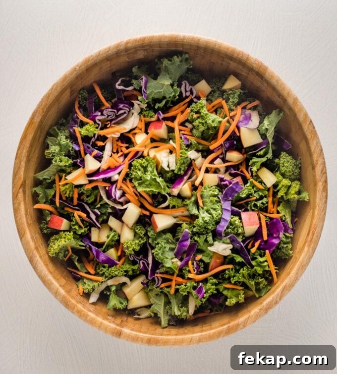 Crunchy Apple Cabbage Slaw with Brown Sugar Cider Vinaigrette 5 Cabbage, greens, carrot, and apple tossed together in a large wooden bowl.