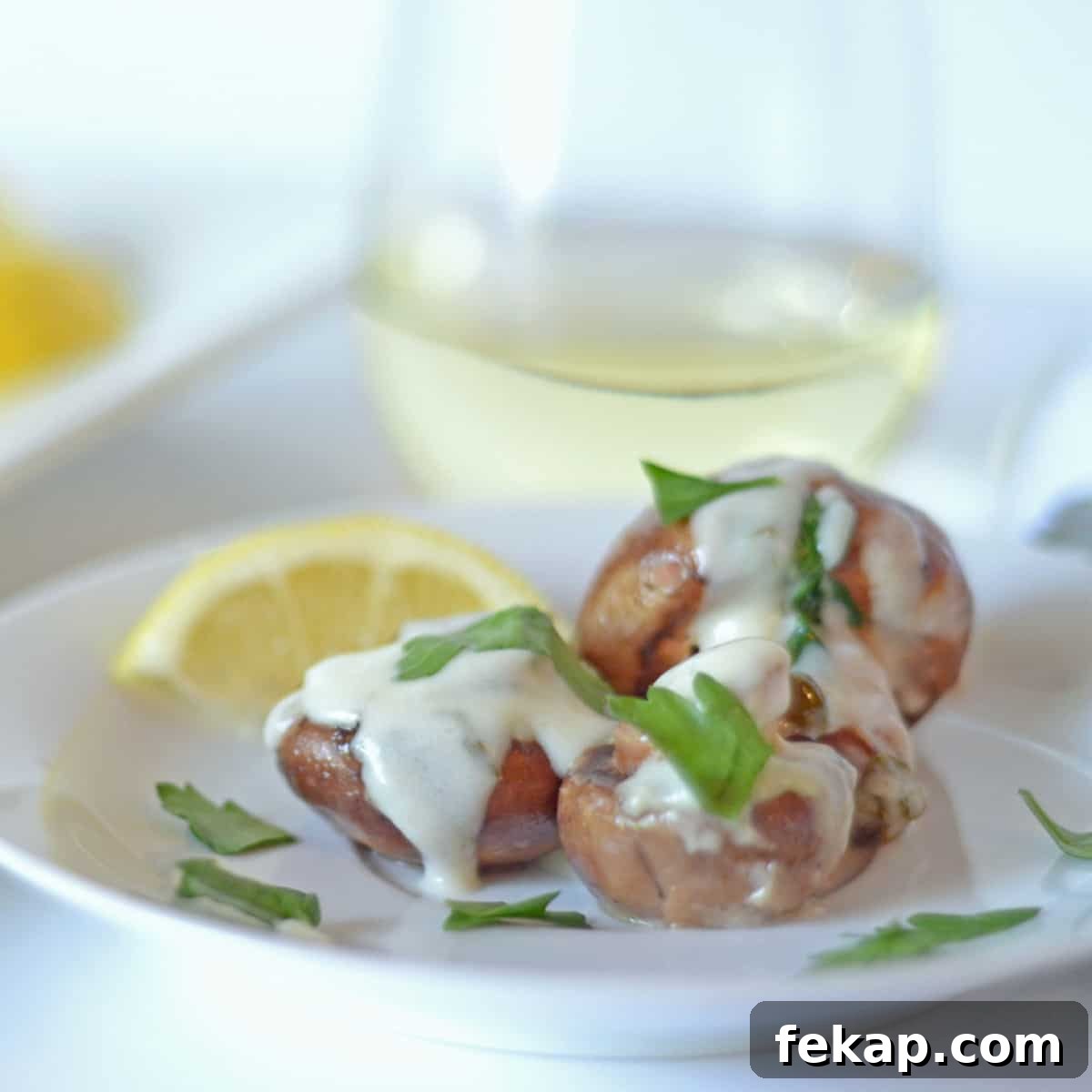 A plate of mushrooms with cream and parsley slathered over them.