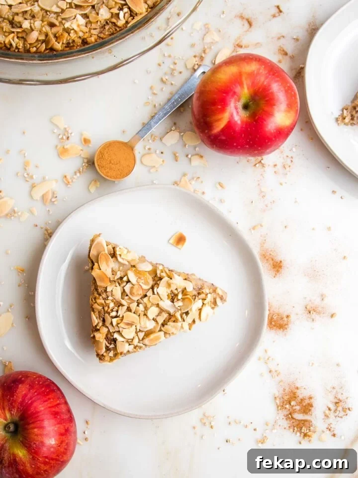 Slice of baked steel cut oats with apples on a white plate.