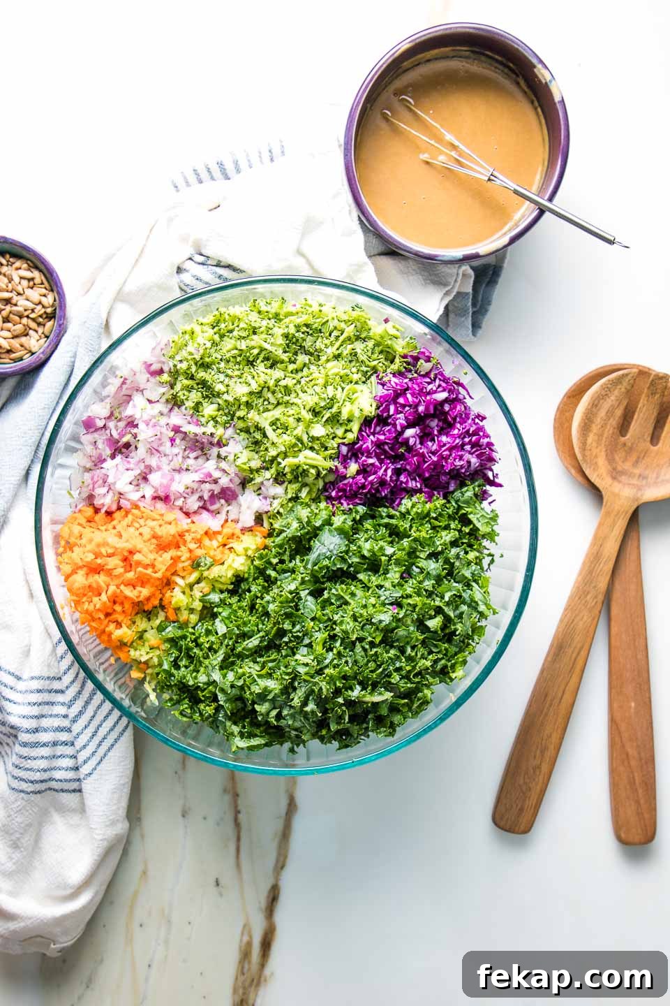 Bowl of colorful chopped veggies and a small bowl of whisked dressing.