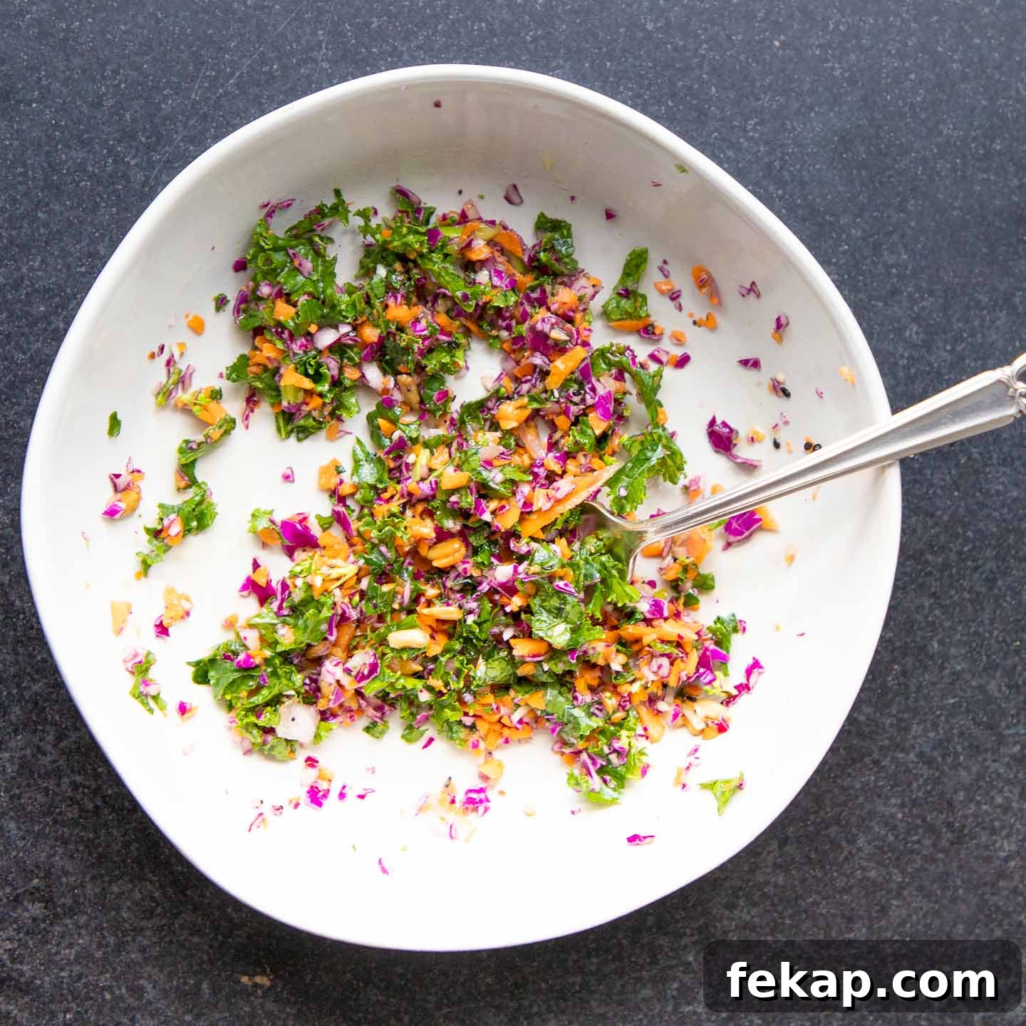 A bowl of brightly colored chopped vegetables.