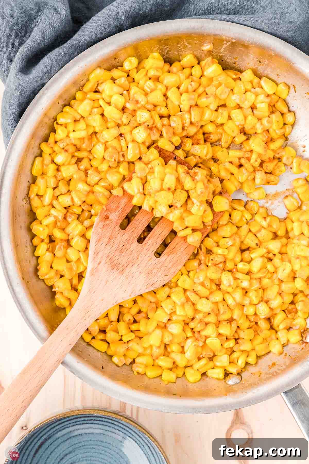 Cajun Fried Corn Recipe: Spicy Southern Side Dish 2 fried corn in a skillet and a wood spoon