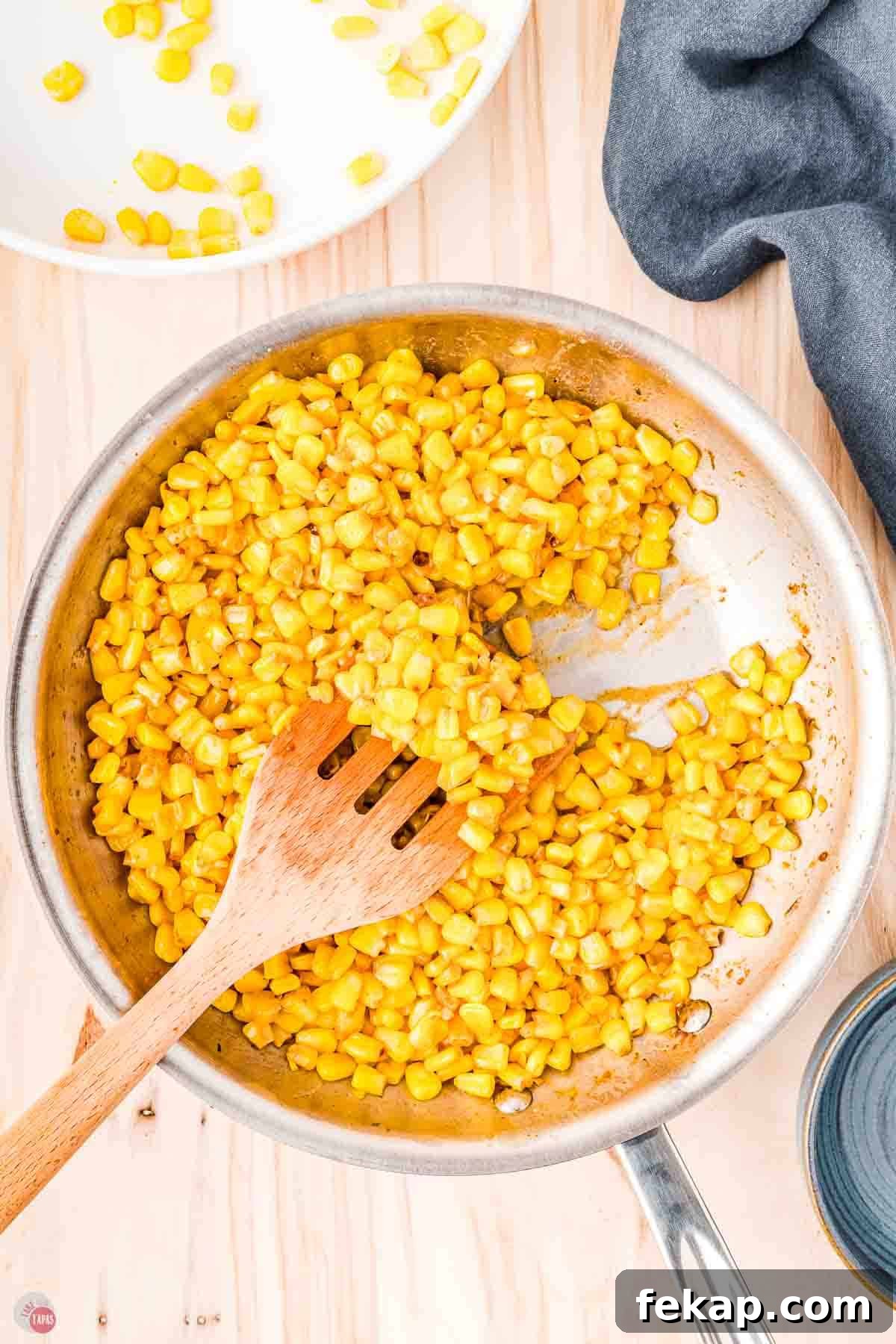 Cajun Fried Corn Recipe: Spicy Southern Side Dish 7 wood spatula moving corn around a skillet