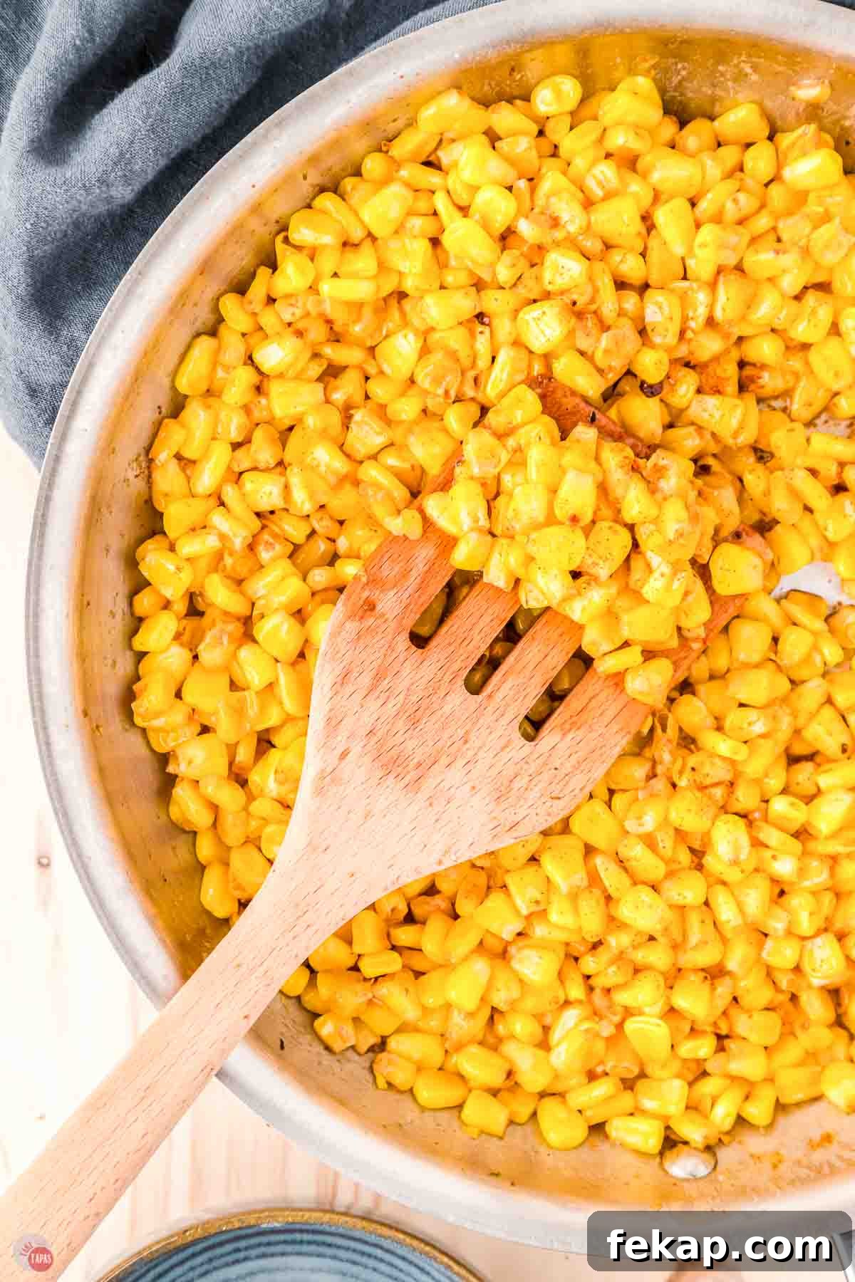 Cajun Fried Corn Recipe: Spicy Southern Side Dish 10 skillet of yellow corn with a wood spoon
