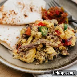 Machaca con huevo recipe made with shredded beef, scrambled eggs, tomatoes, onions, and jalapeños, served with warm flour tortillas and salsa, by Yvette Marquez-Sharpnack of Muy Bueno Mexican recipes.