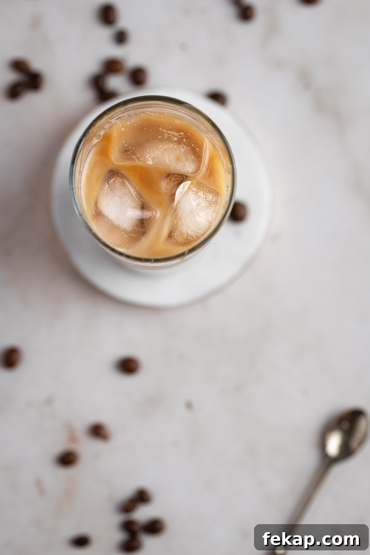 How to Make Caramel Iced Coffee at Home 7 Overhead view of an iced caramel coffee on a white marble table.