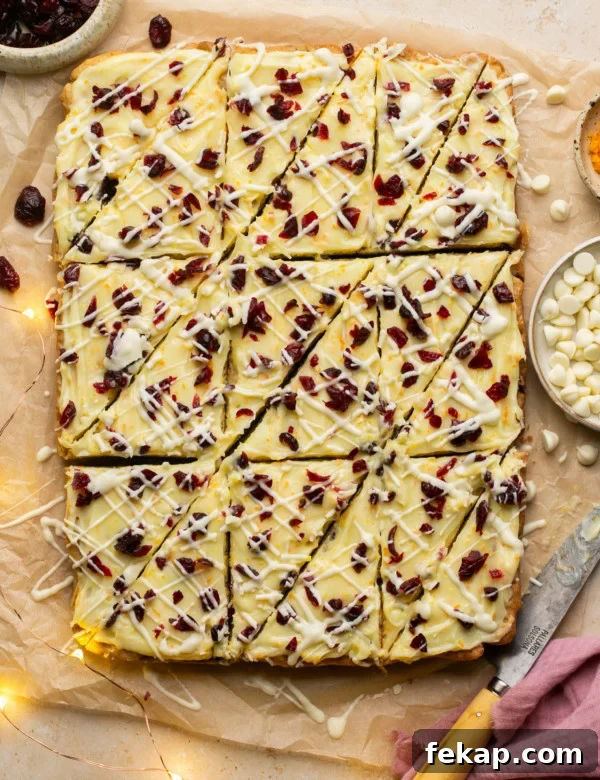 sheet of cranberry bliss bars with triangle cuts made