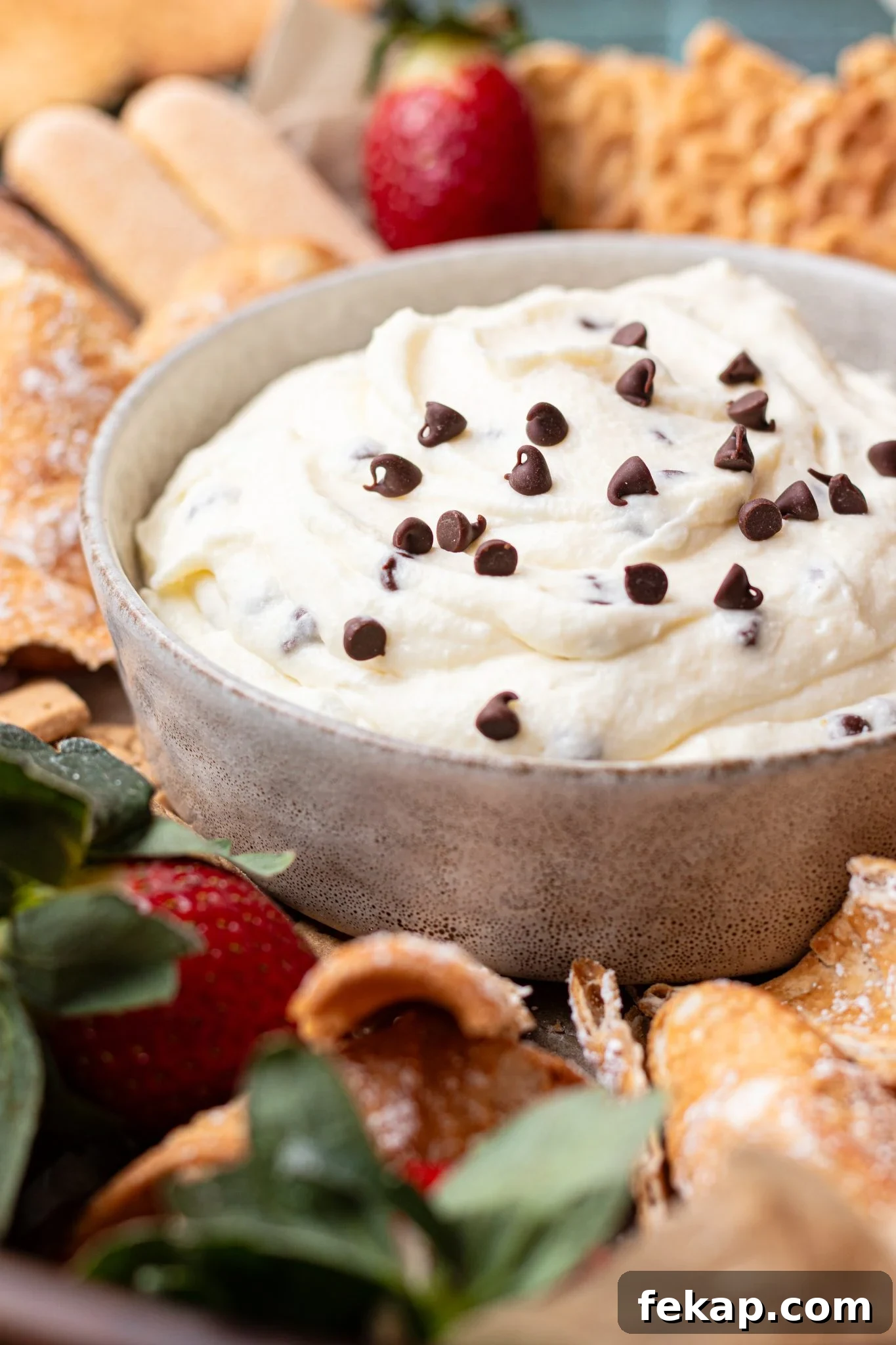 Creamy Ricotta Cannoli Dip with Chocolate Chips 8 a bowl filled with cannoli dip and sprinkled with mini chocolate chips on top.
