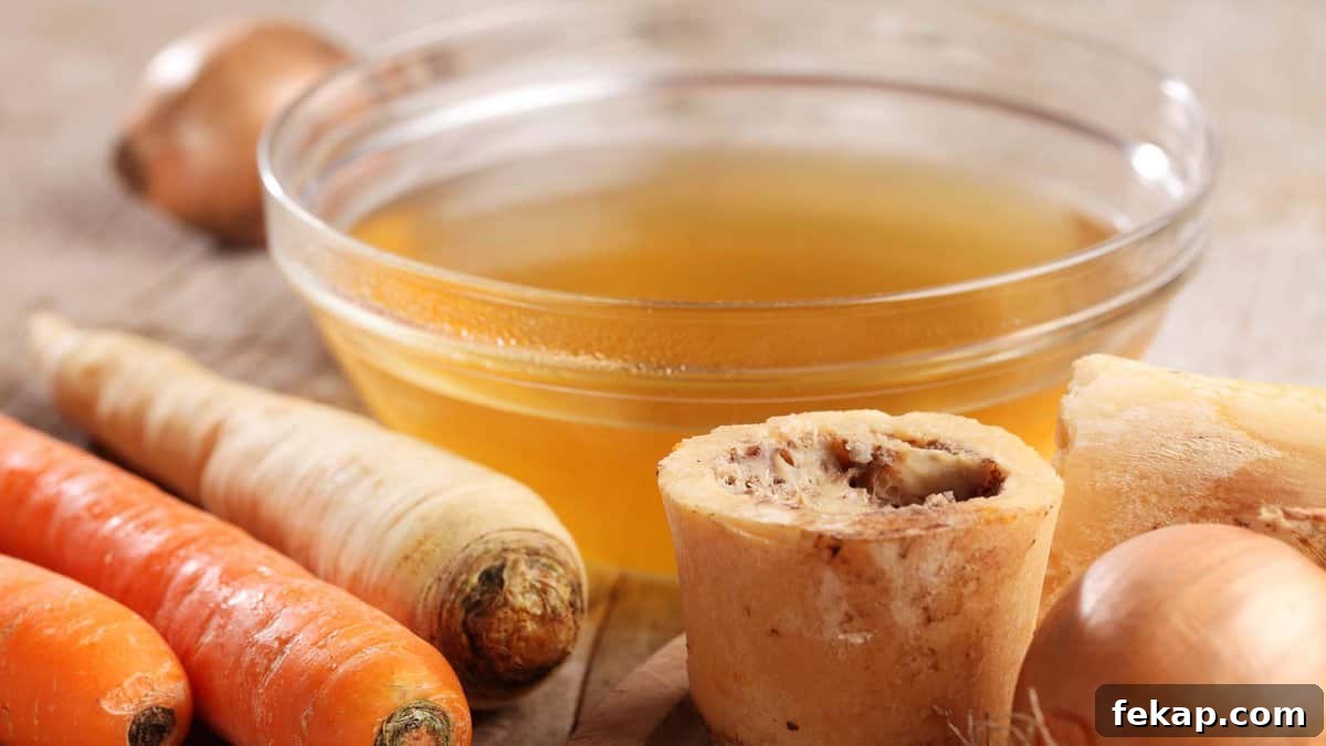 Broth Stock and Bone Broth Differences Explained 5 A bowl of broth and carrots next to a bowl of broth.