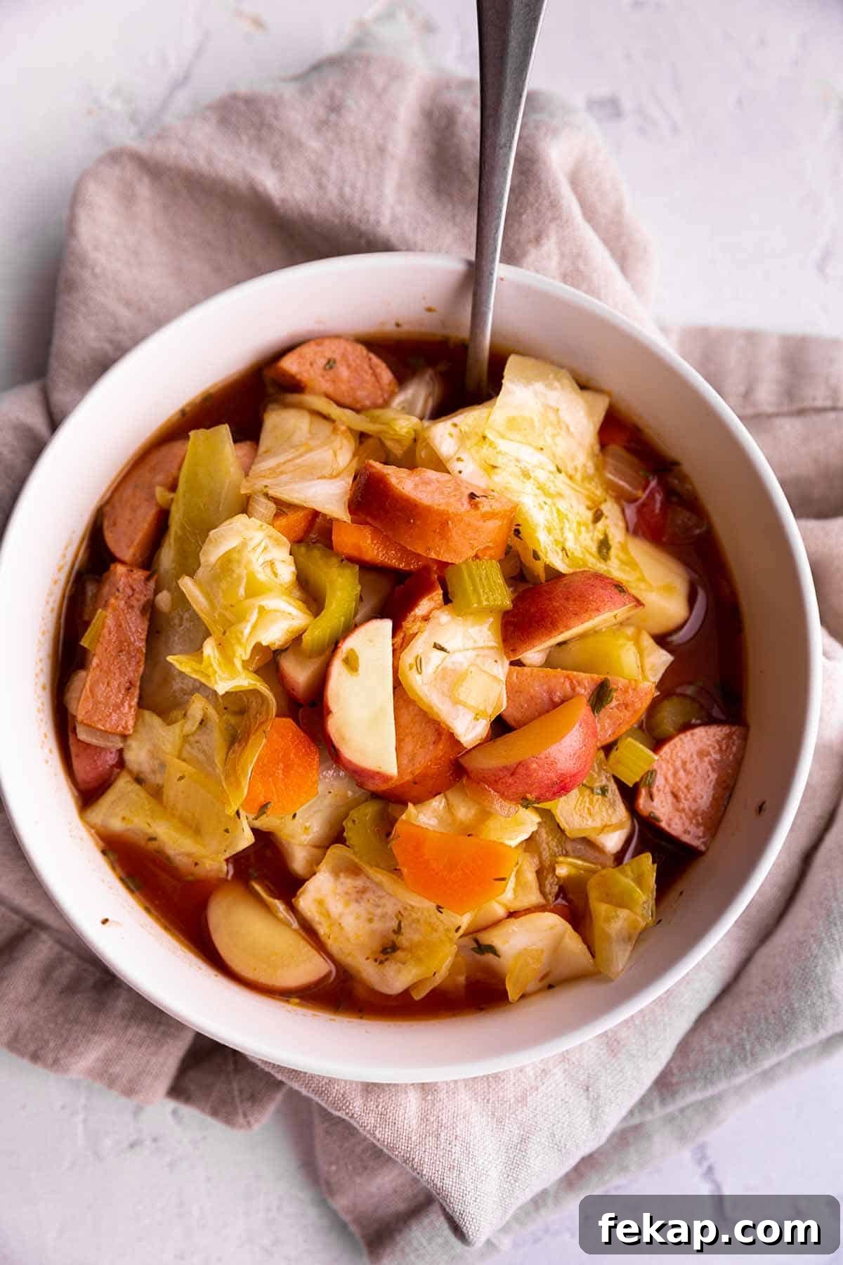 One Pot Cabbage and Sausage Soup Recipe 5 A bowl of cabbage soup with potatoes and sausage.