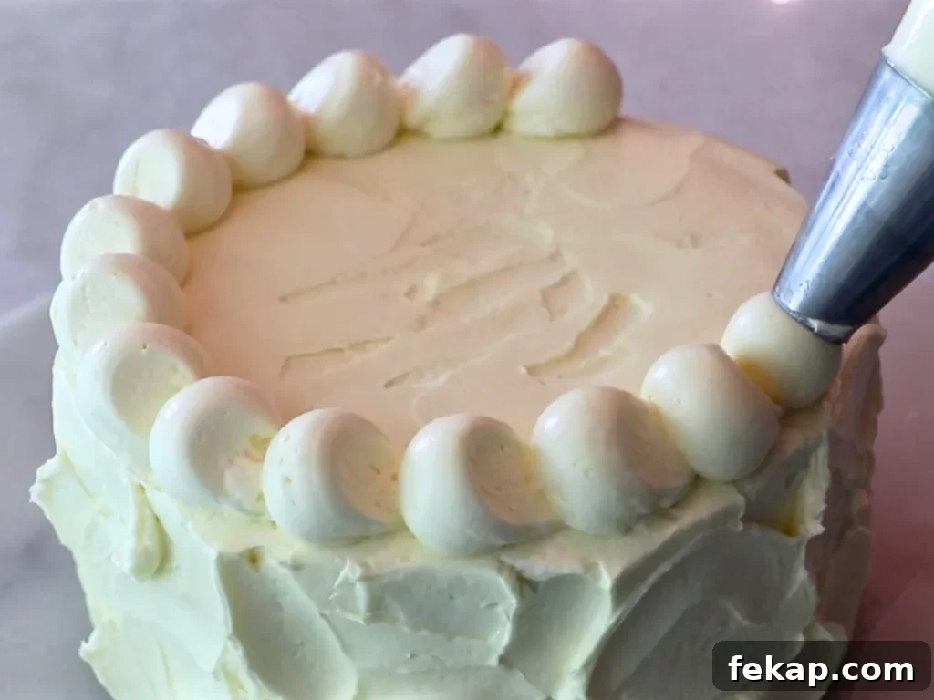 piping lemon buttercream on top of a cake