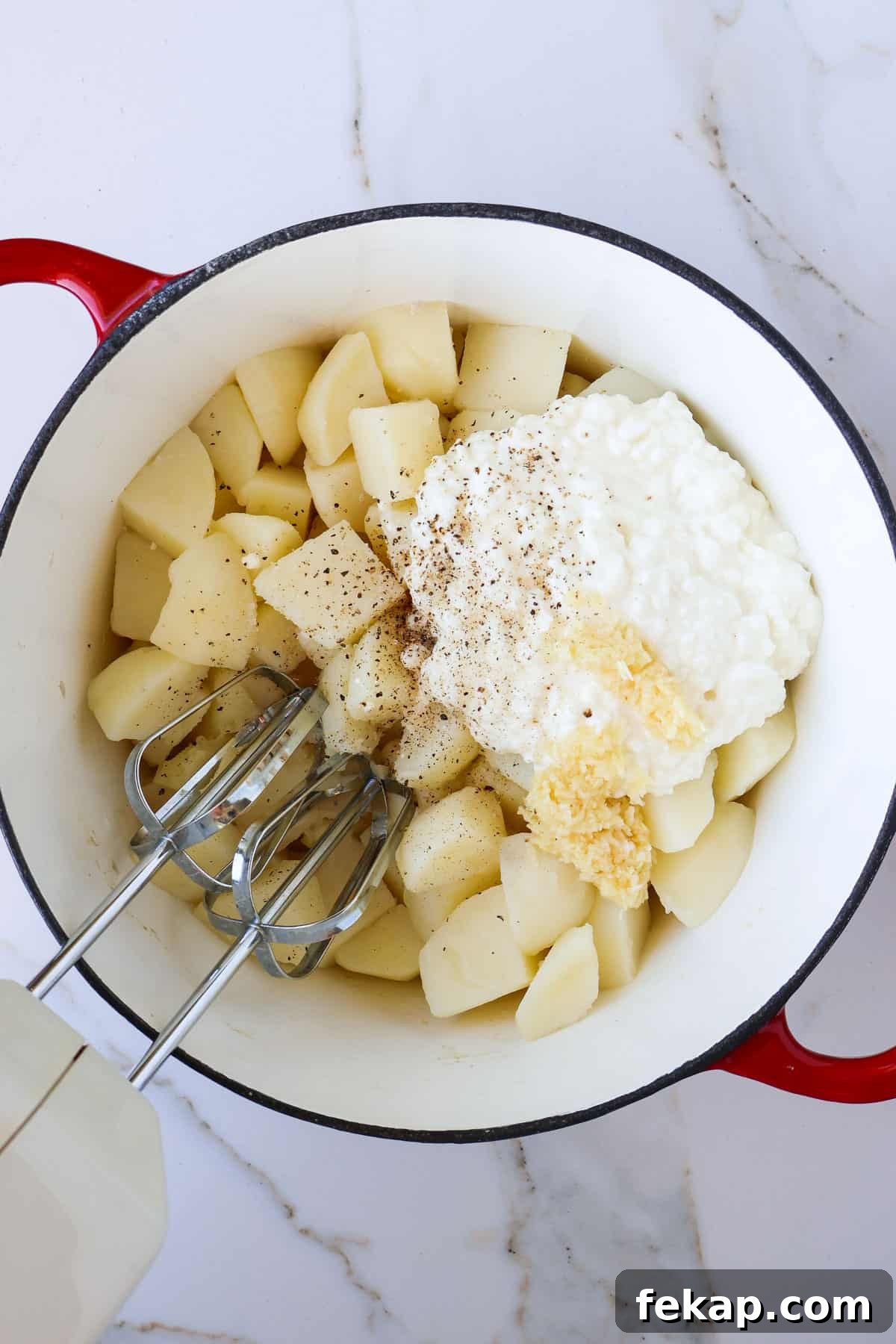 Creamy Cottage Cheese Mashed Potatoes Recipe 6 Cooked potatoes in a pot with cottage cheese, butter, milk, garlic, salt, pepper and a blender.