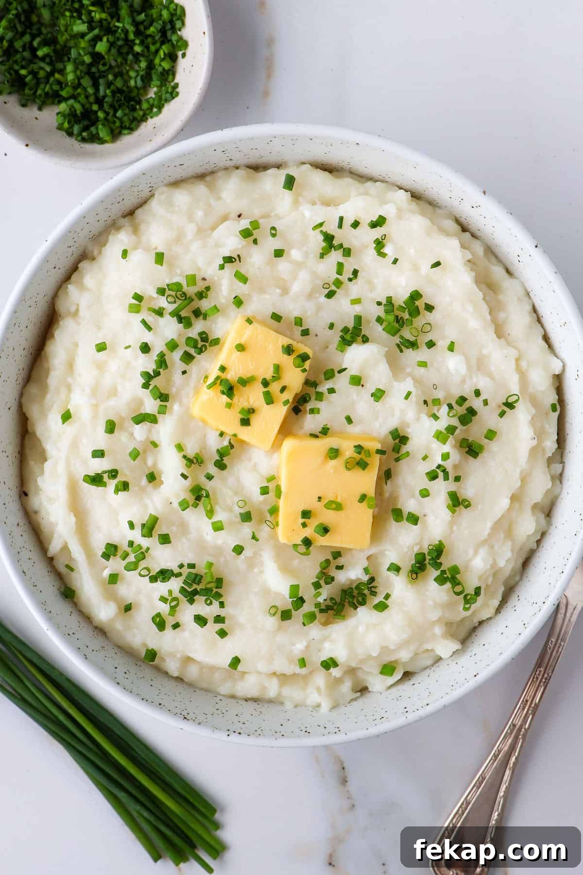 Creamy Cottage Cheese Mashed Potatoes Recipe 8 Mashed potatoes in a bowl. With a spoon on the side.