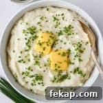 Mashed potatoes in a bowl with a spoon.