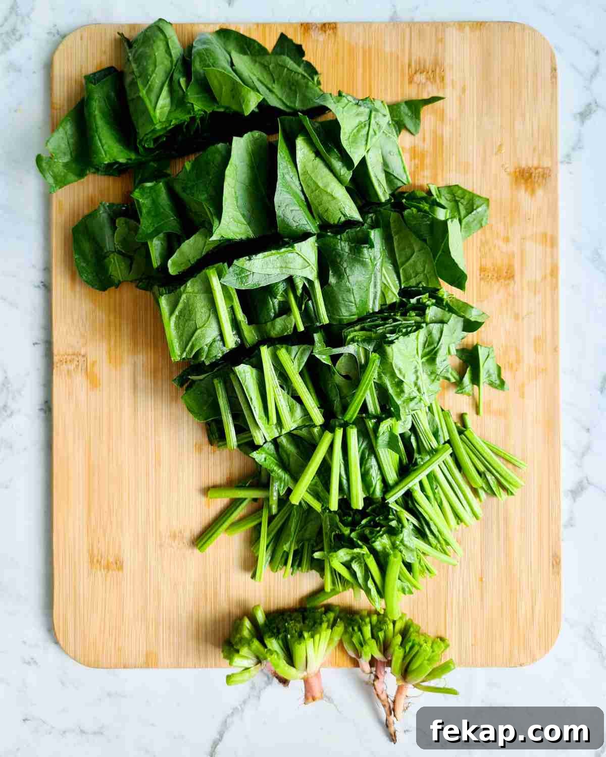 Garlic Stir-Fried Spinach Recipe 11 A bunch of washed spinach cut up into 4cm segments on a wooden cutting board