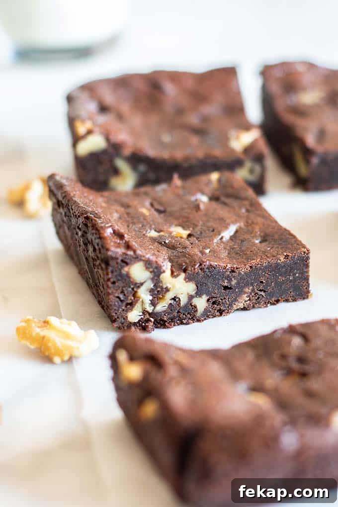 A side angle view showing a vegan brownie with walnuts.