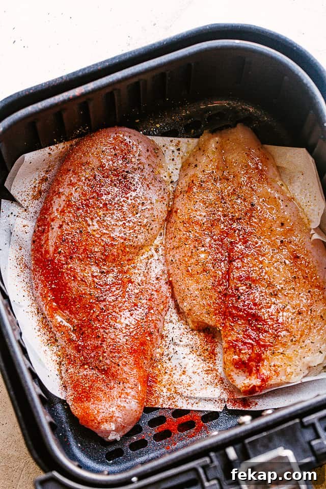 Raw chicken breasts in an air fryer.