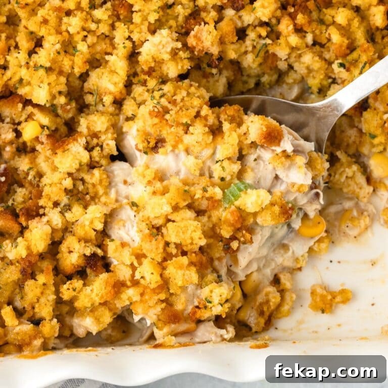 A close up view of a large spoon of Chicken and Stuffing Casserole.