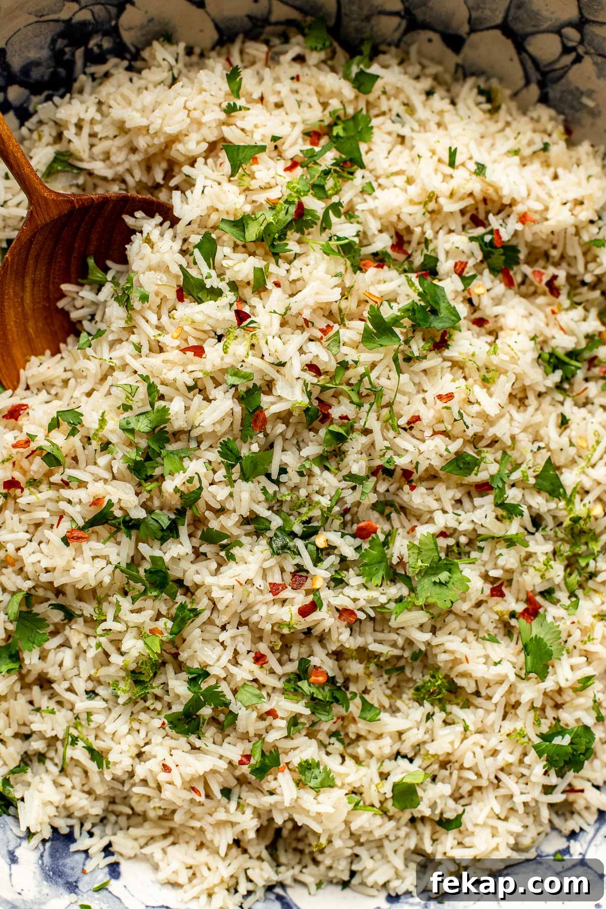 A close up image of rice with cilantro and chili flakes on top. 
