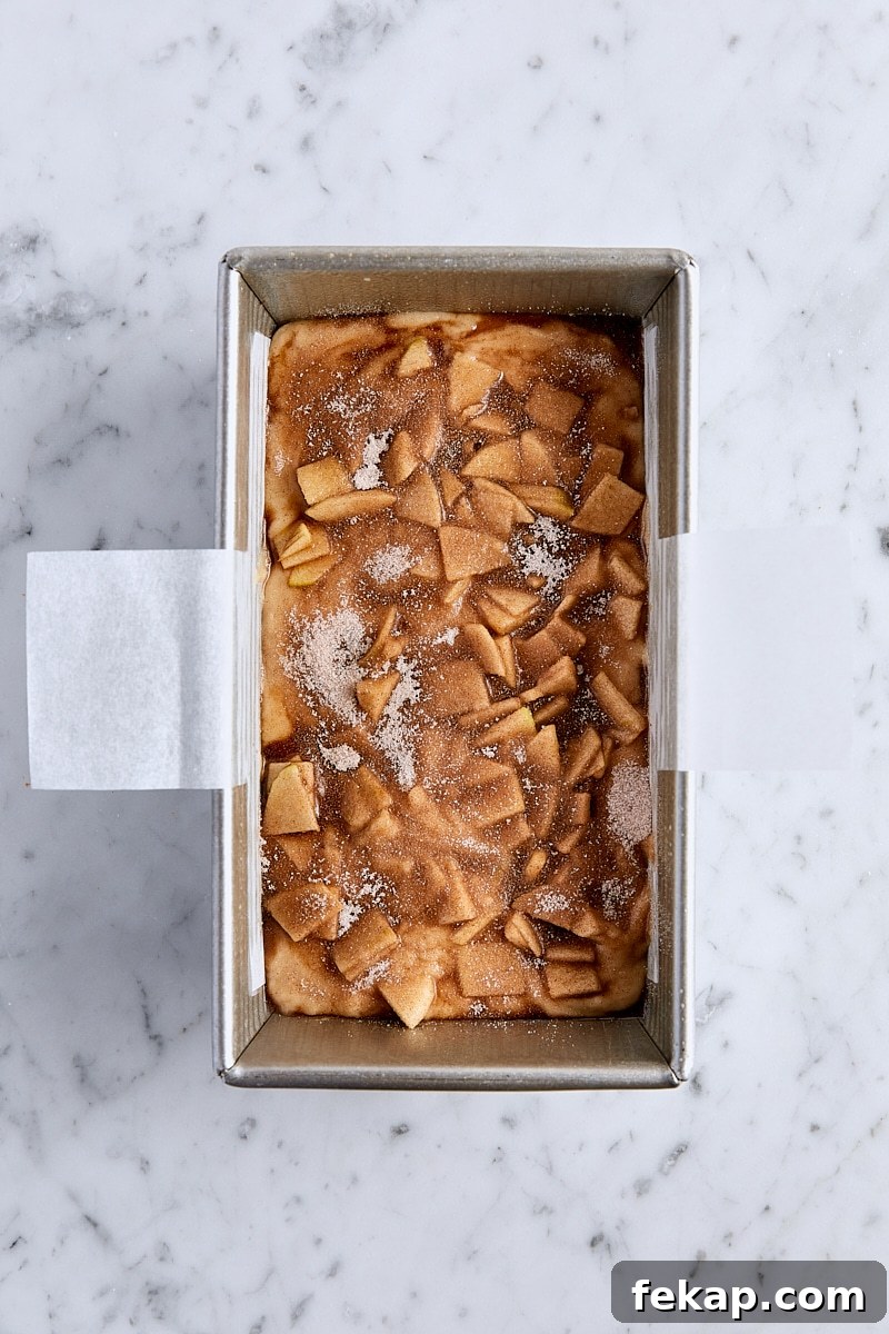 Cinnamon sugar sprinkled over the top of unbaked apple fritter bread