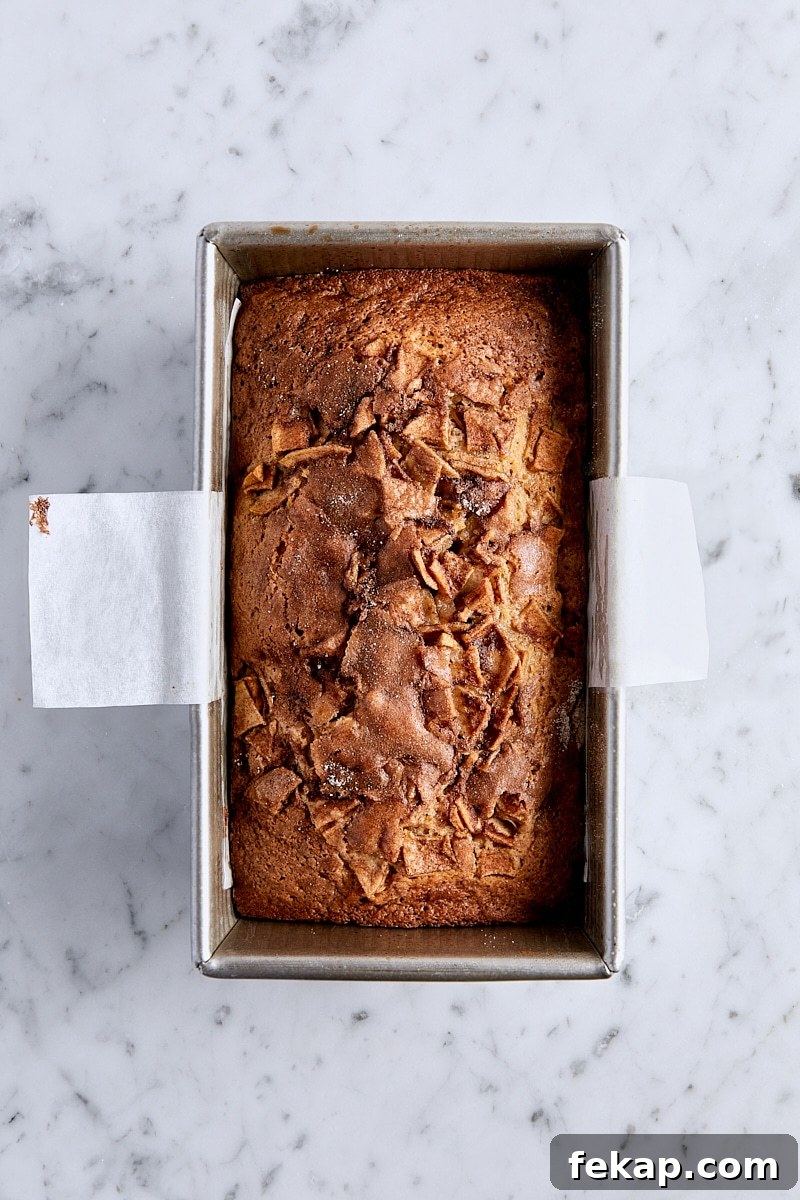 Baked apple fritter bread in parchment-lined loaf pan