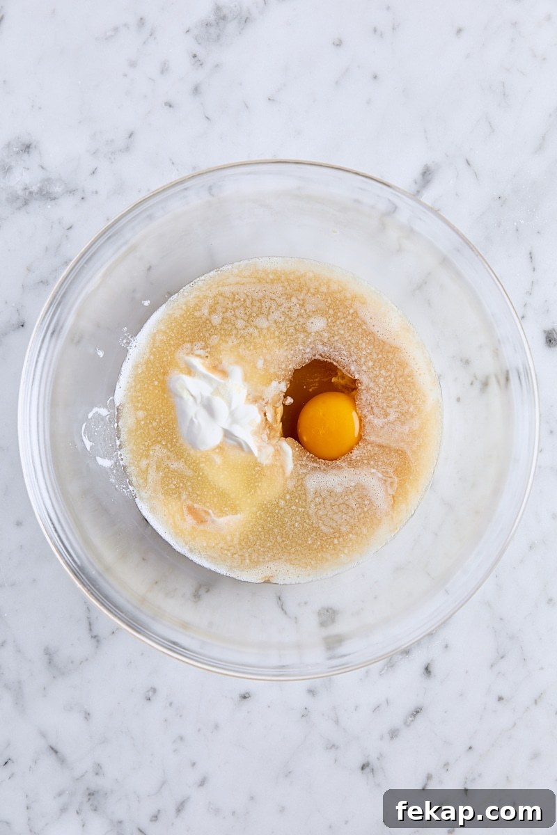 Melted butter, oil, apple cider, sour cream, egg, and vanilla extract in glass bowl