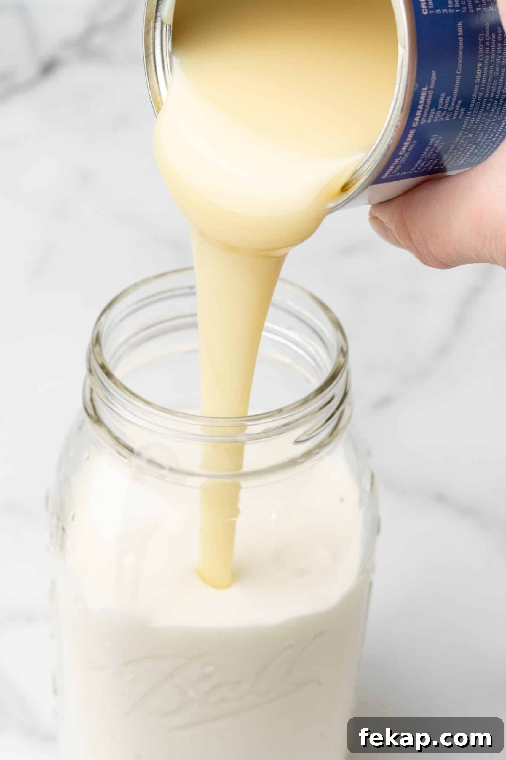 Make Your Own Hazelnut Coffee Creamer 5 sweetened condensed milk being poured into a glass jar filled with milk