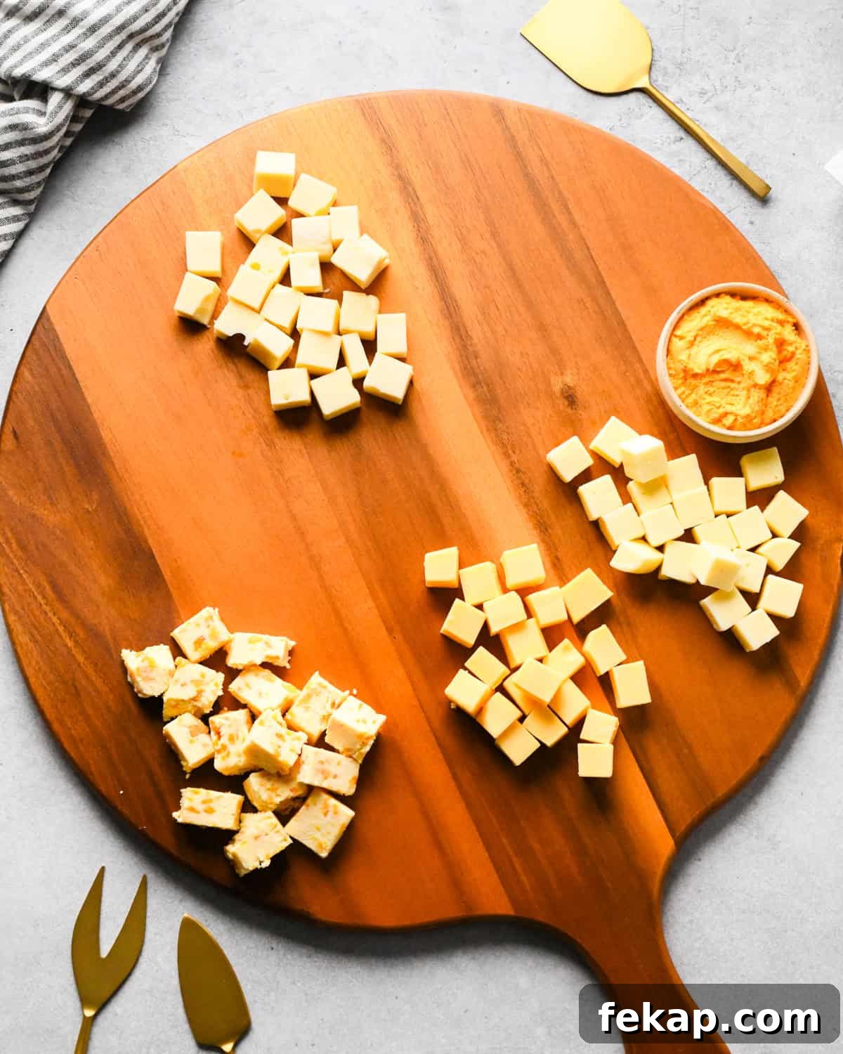 How to Make a Charcuterie Board - cubed cheese arranged spaced out on a round wood board