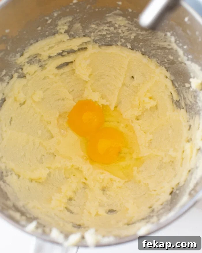 Cut Out Sugar Cookie Recipe for Perfect Shapes 12 Butter and sugar mixture mixed with two raw eggs on top in a stand mixer bowl.