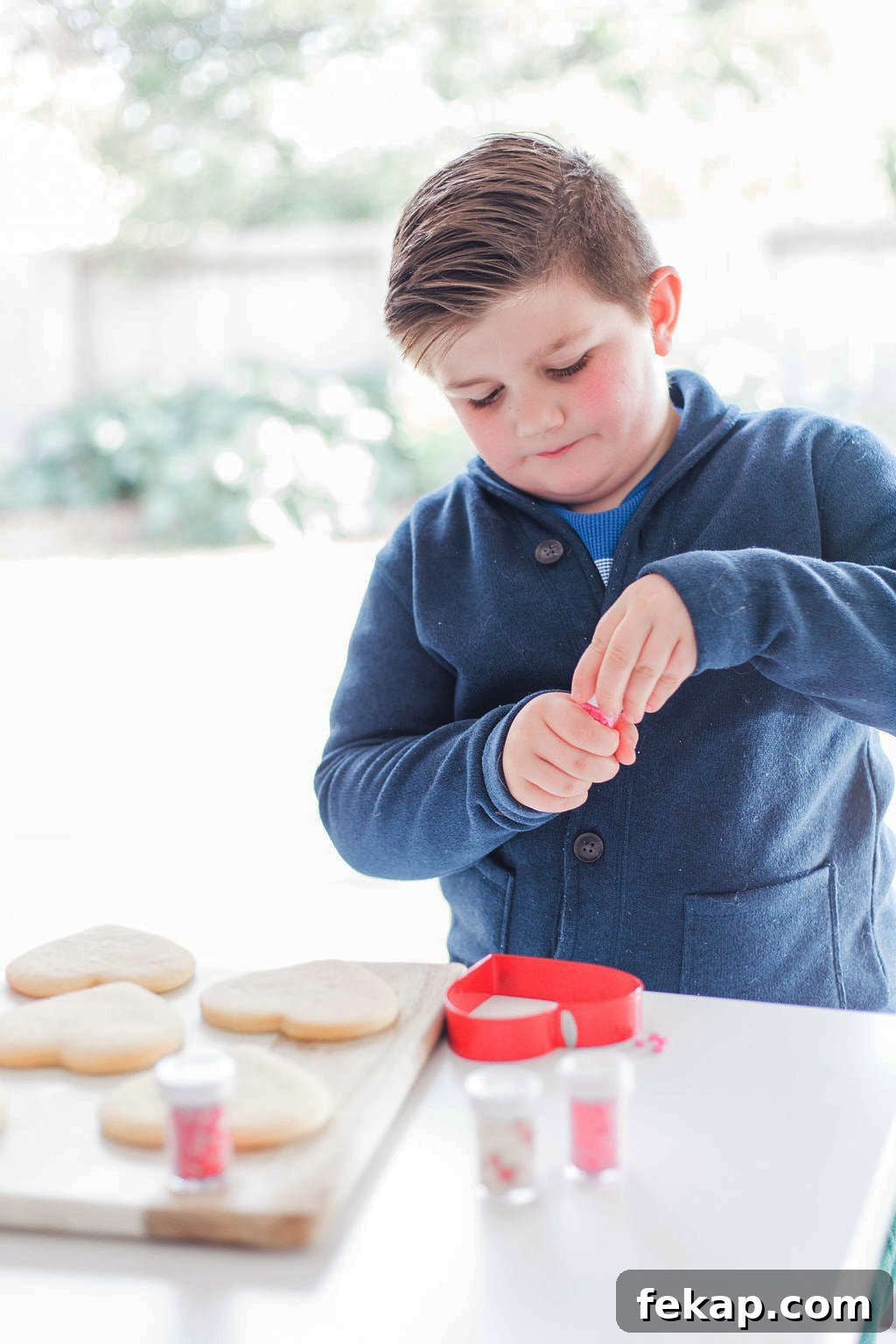 Cut Out Sugar Cookie Recipe for Perfect Shapes 5 A small boy decorating cookies.
