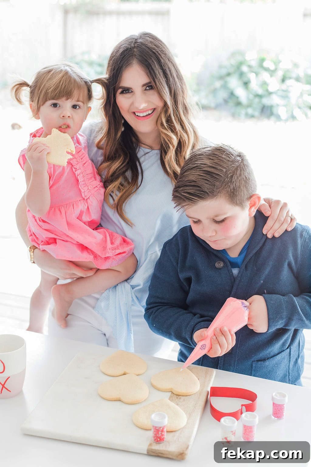 Cut Out Sugar Cookie Recipe for Perfect Shapes 7 A mother and her small children decorating cookies.