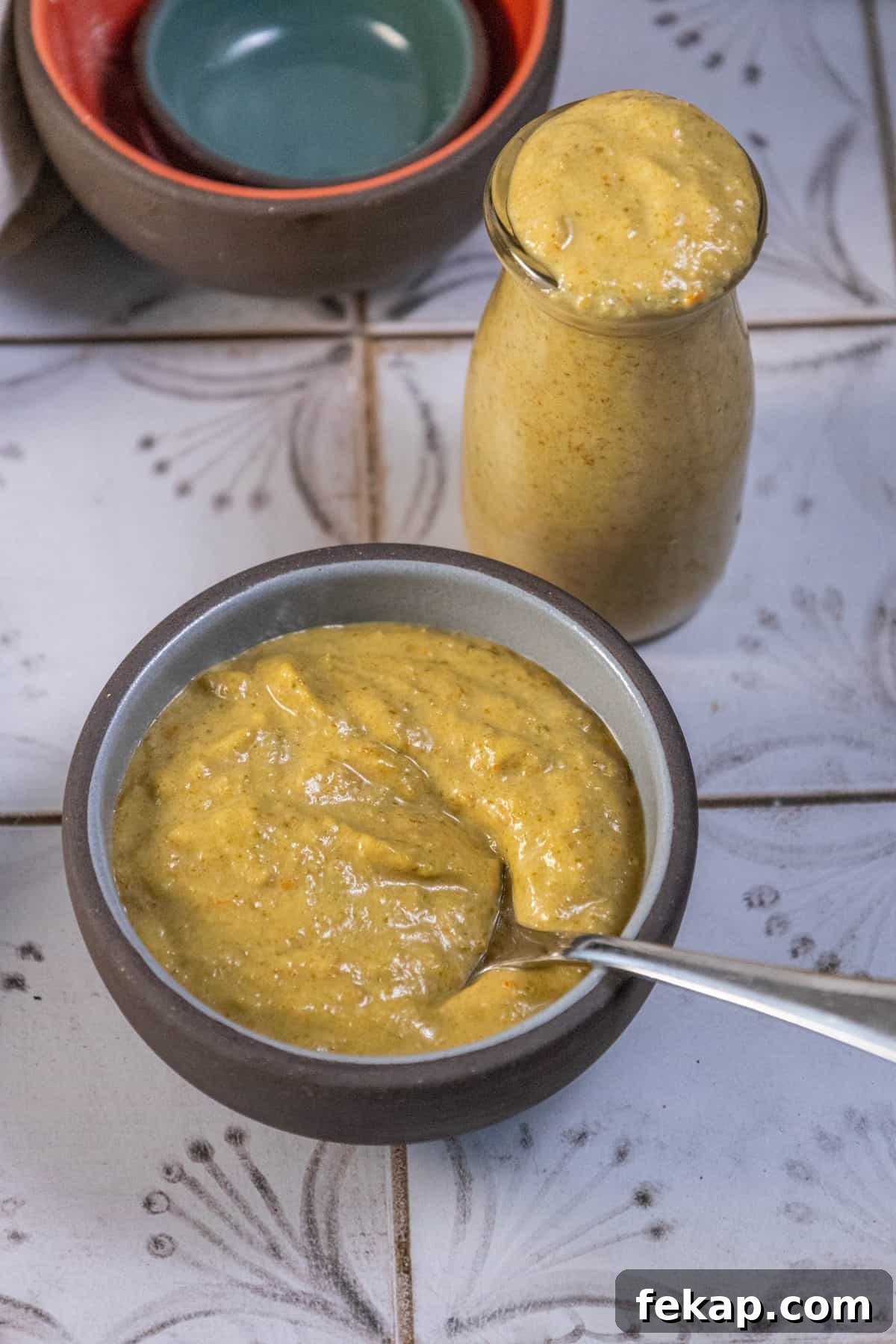 Homemade Habanero Hot Sauce Recipe: Fiery Flavor 3 A bowl of yellow soup with a spoon next to it, topped with a drizzle of hot sauce.