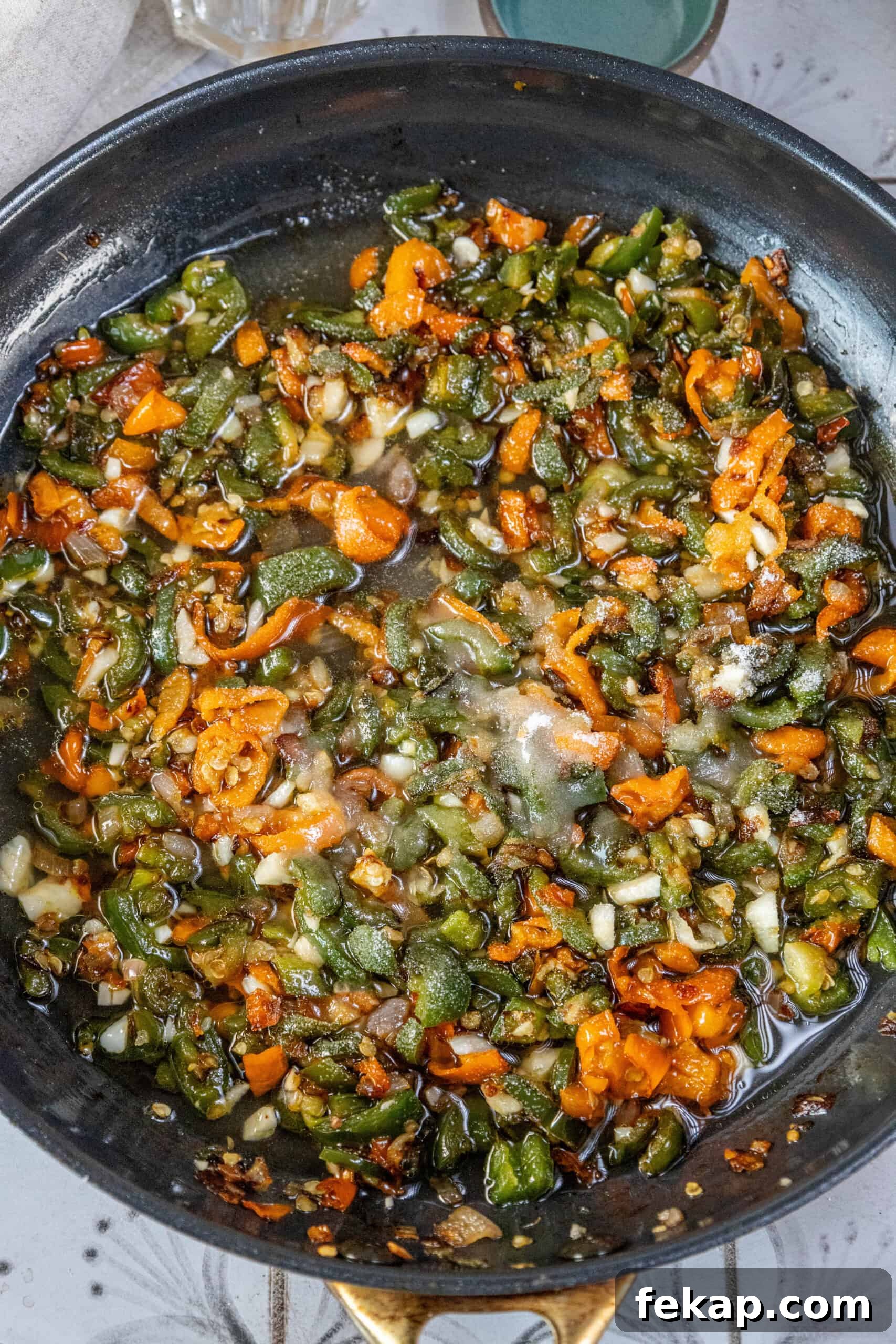 Homemade Habanero Hot Sauce Recipe: Fiery Flavor 6 A frying pan sizzling with vegetables drenched in habanero-infused flavors.