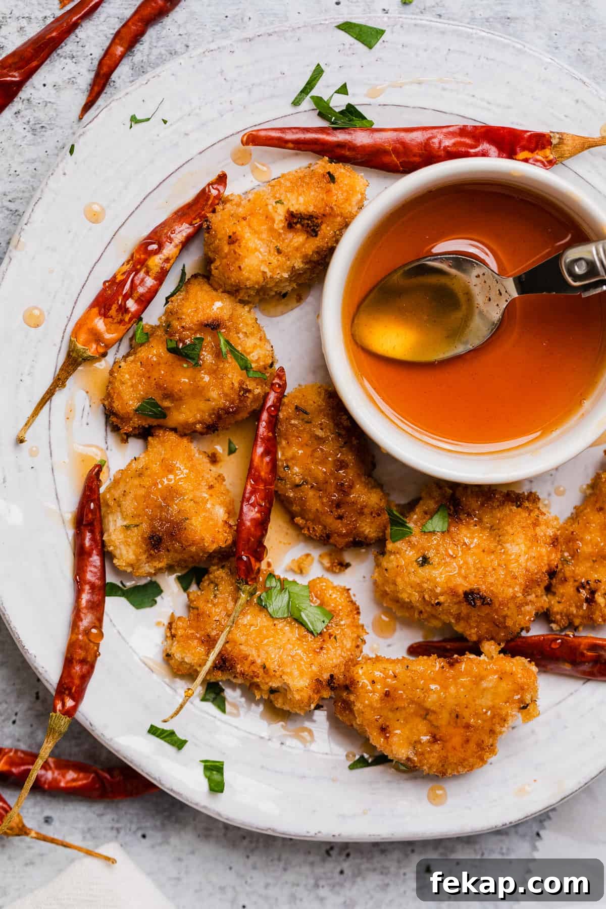a plate of chicken nuggets with hot honey drizzled over