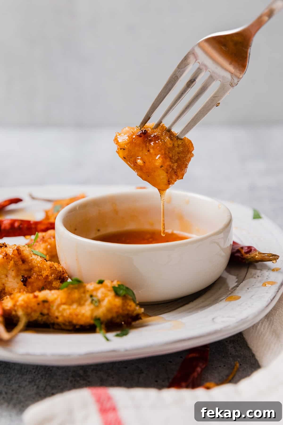 dipping a chicken nugget into a bowl of hot honey